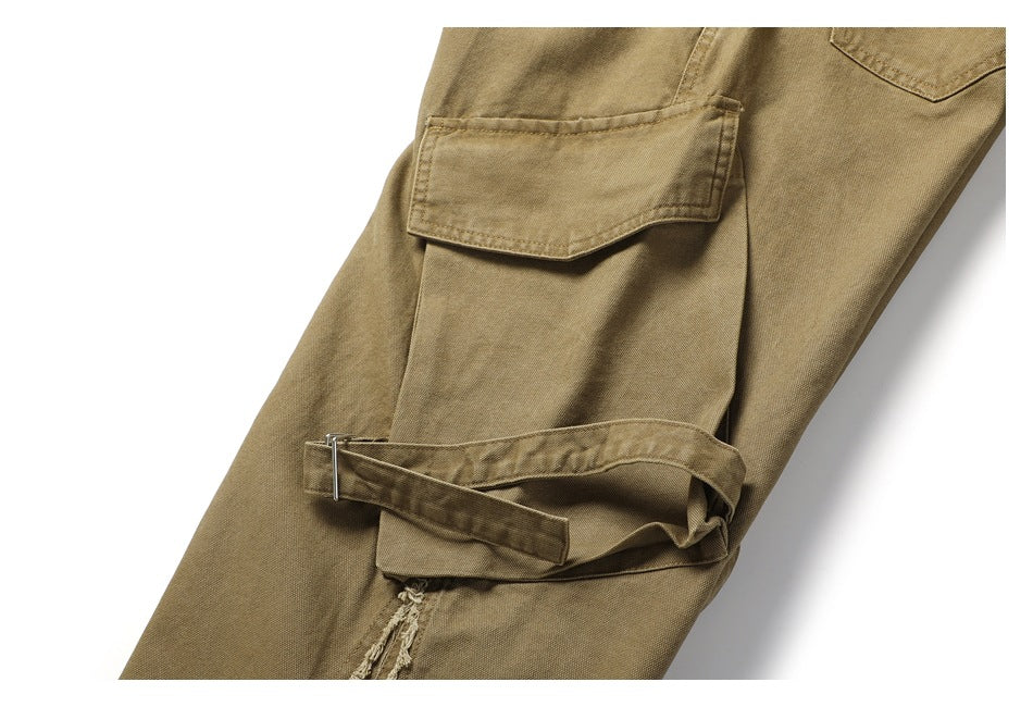 Close-up of khaki trousers with a flap cargo pocket, adjustable strap and frayed seam detail.