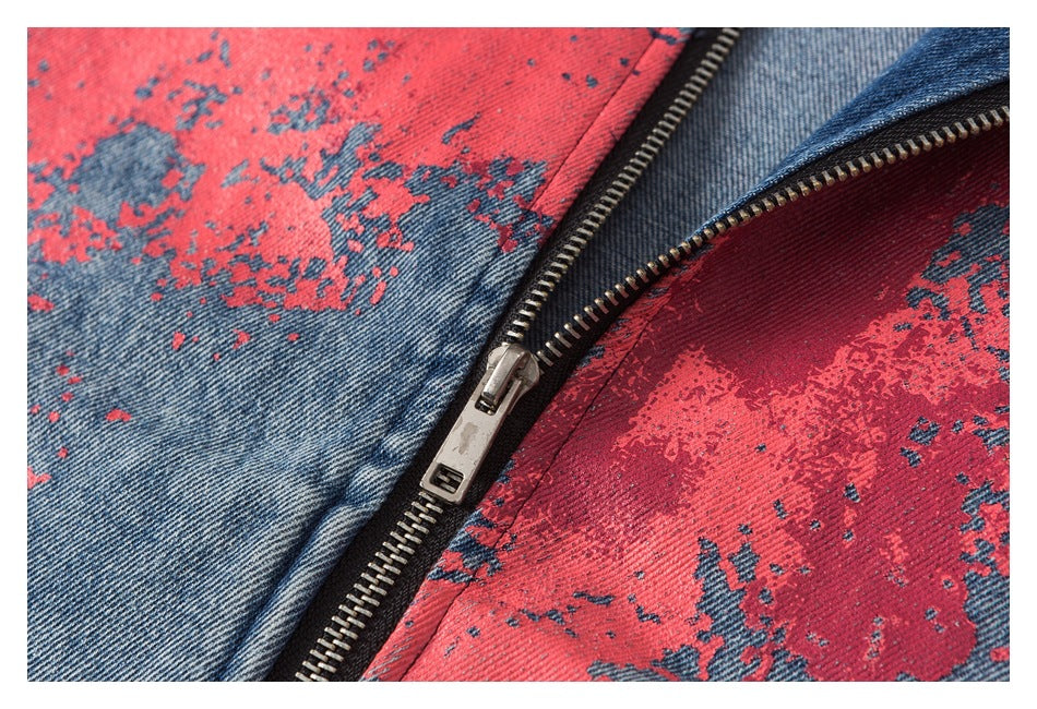 Close-up of a metal zipper between blue denim panels with a distressed red print.