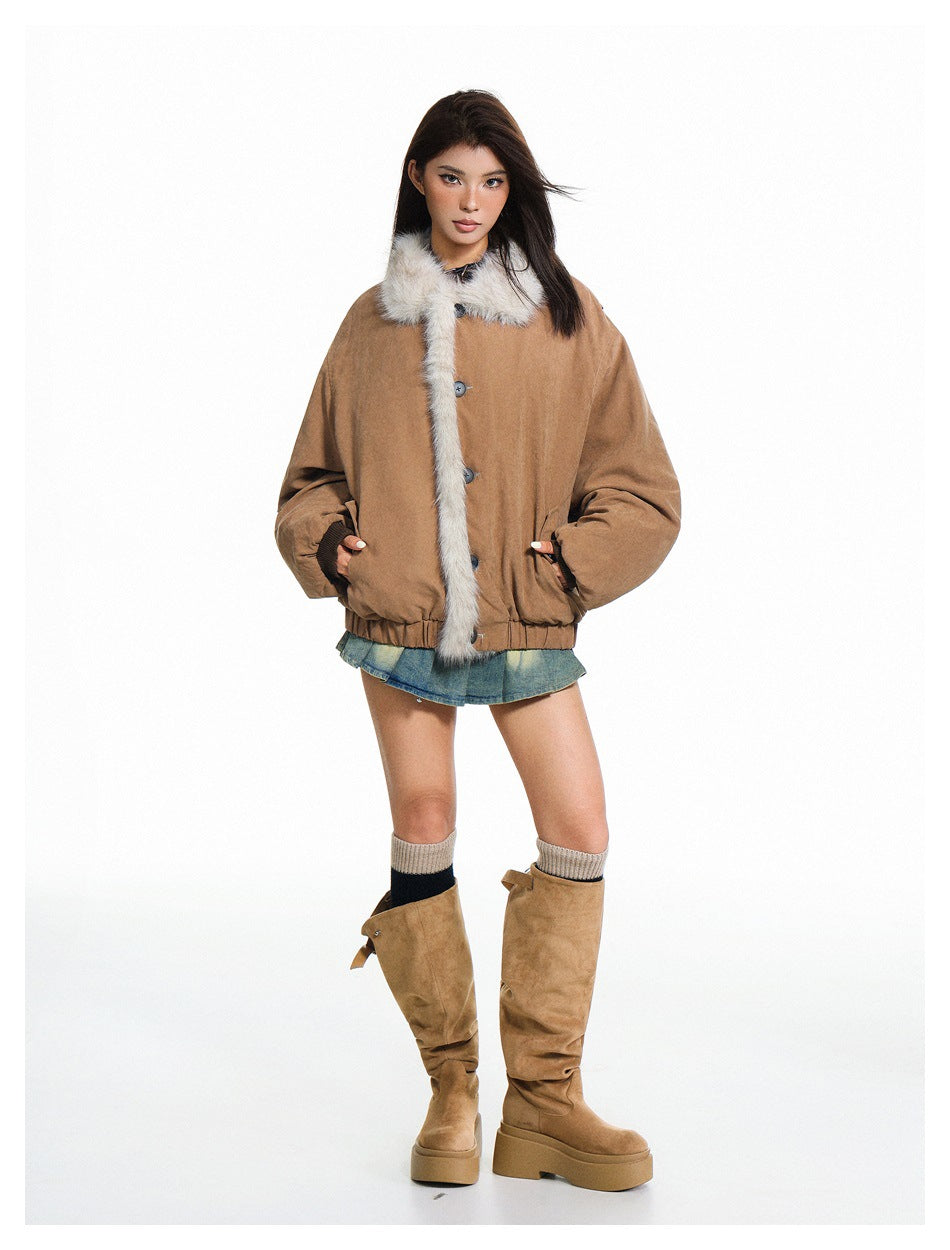 Model wearing a loose camel-brown jacket with a cream faux-fur collar and front trim, styled with a denim mini skirt and tall