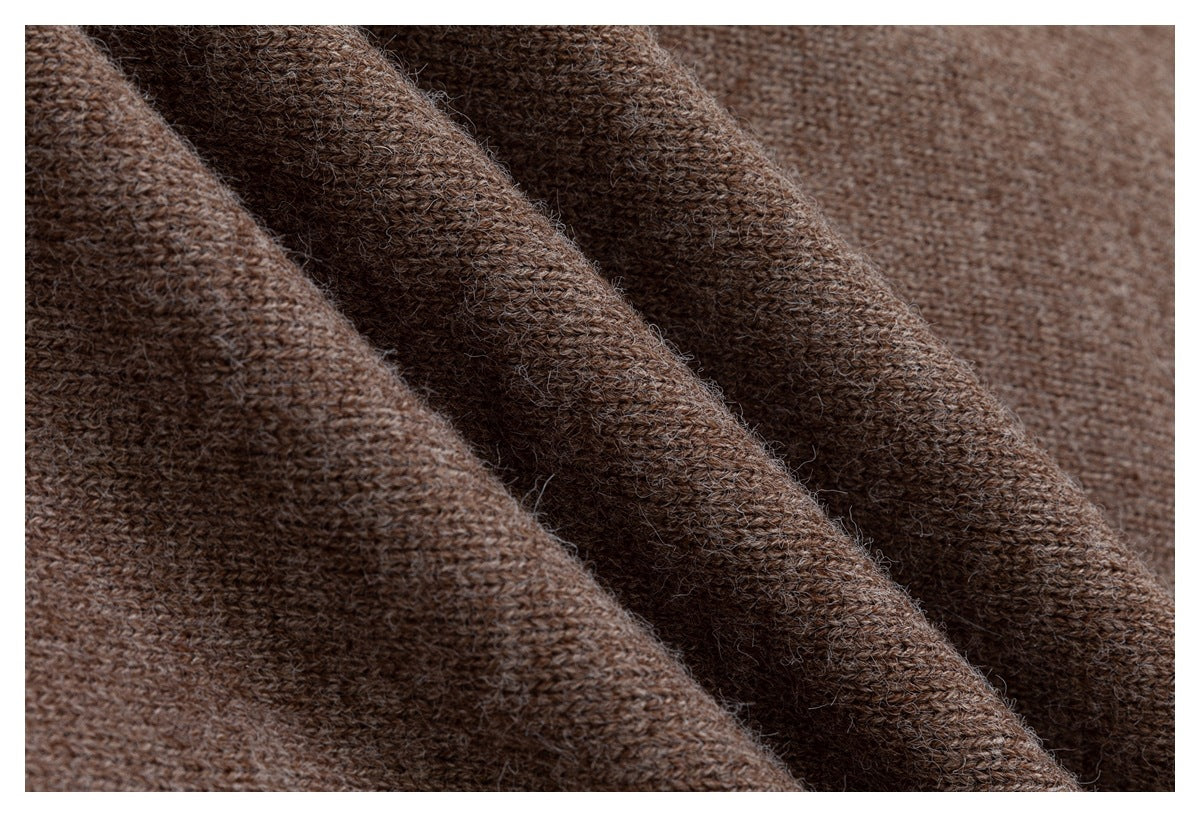 Close-up of brown knitted fabric draped in soft folds, showing its textured weave.