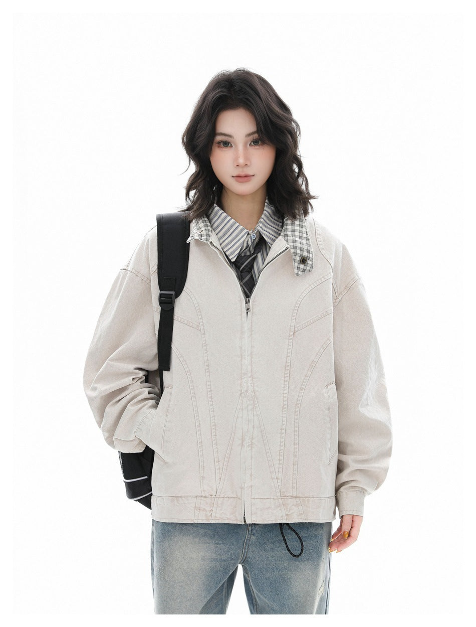 Model wearing a light beige zip-front jacket with curved panel seams and a plaid-lined collar.