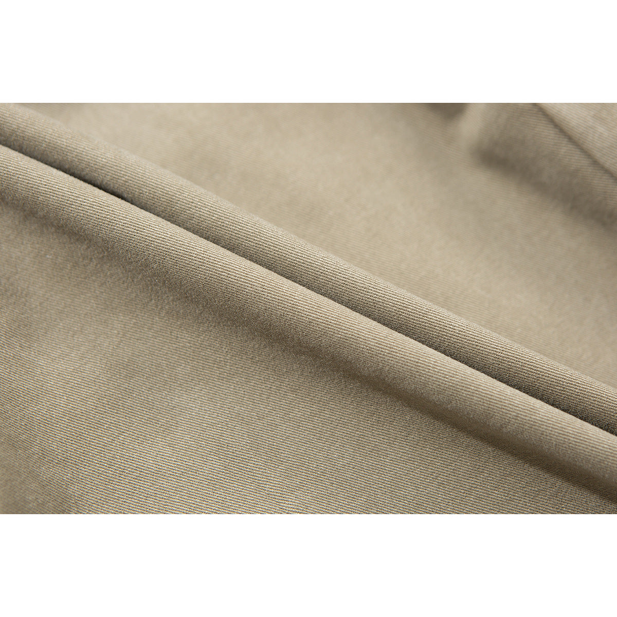 Close-up of tan fabric draped into a fold, showing its fine diagonal texture.