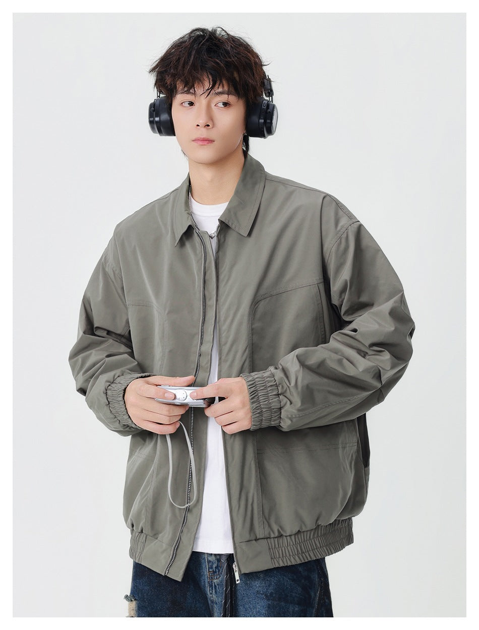 Model wearing a gray-green zip jacket with a pointed collar, elastic cuffs and hem, and front pockets.