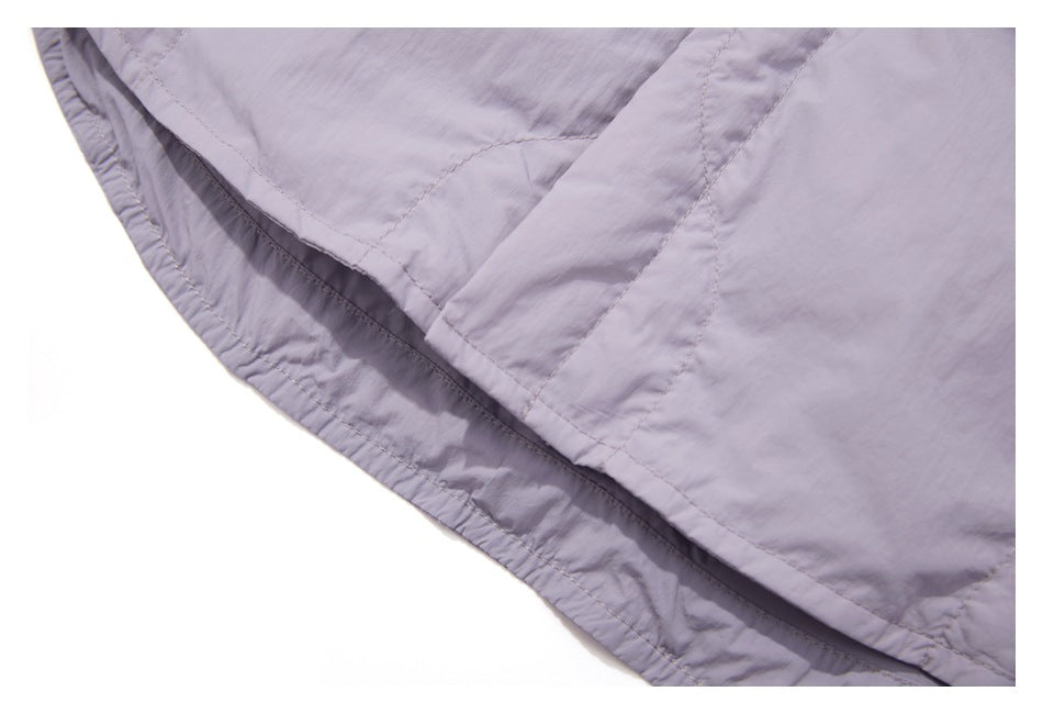 Close-up of the lavender jacket's curved hem and stitched quilting.