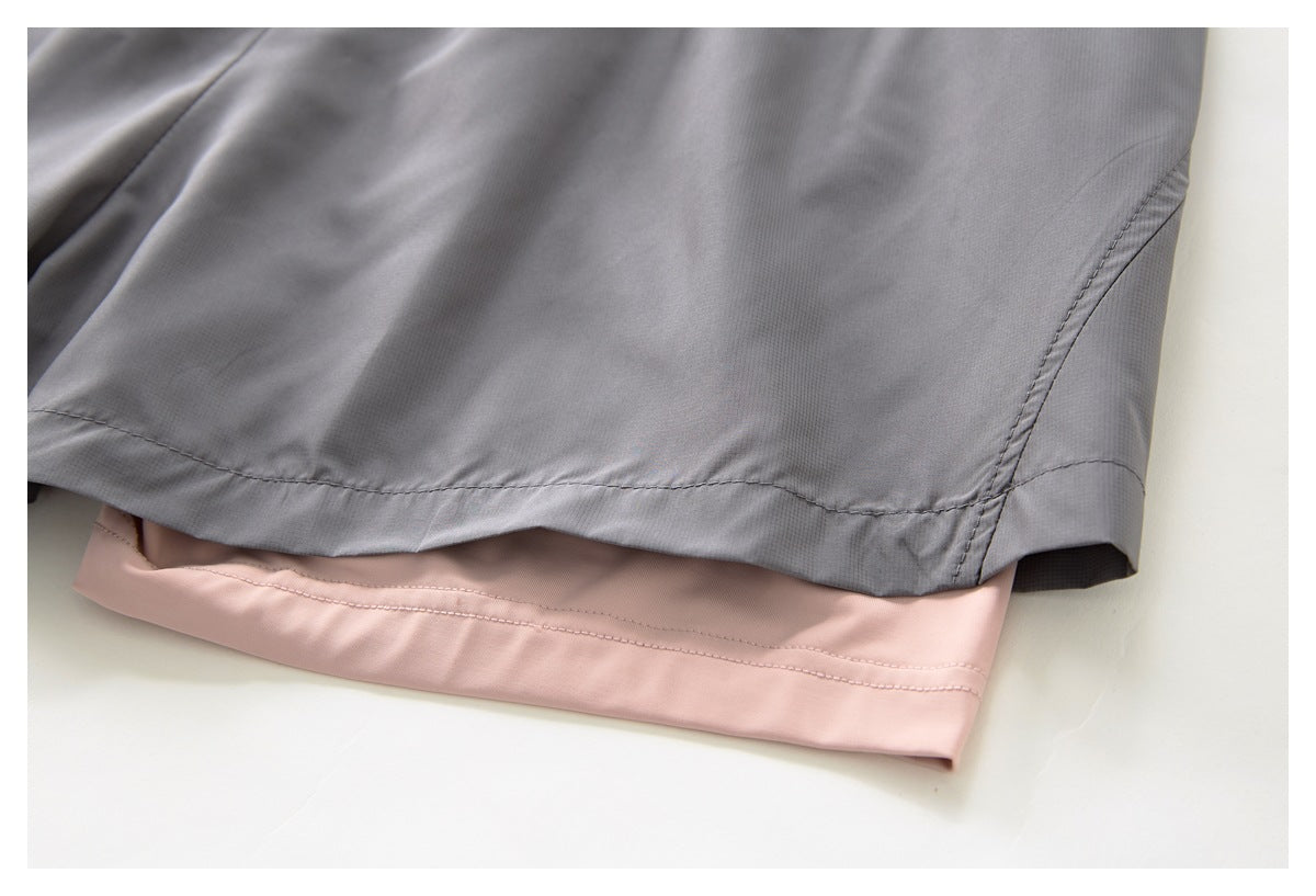 Close-up of gray shorts hem layered over a pale pink garment hem.
