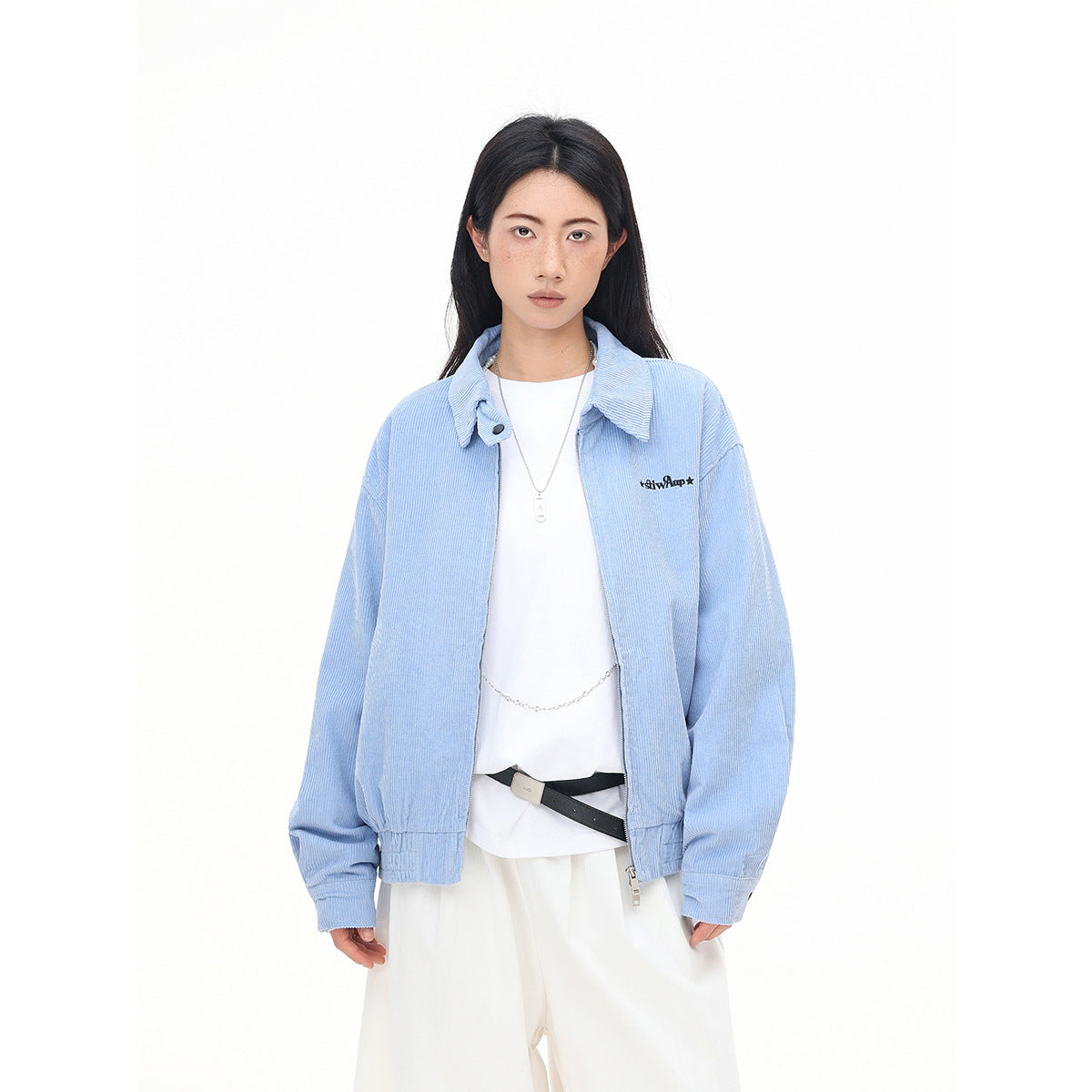 Front view of a model in a light blue collared zip jacket with elastic cuffs and hem, paired with white trousers.