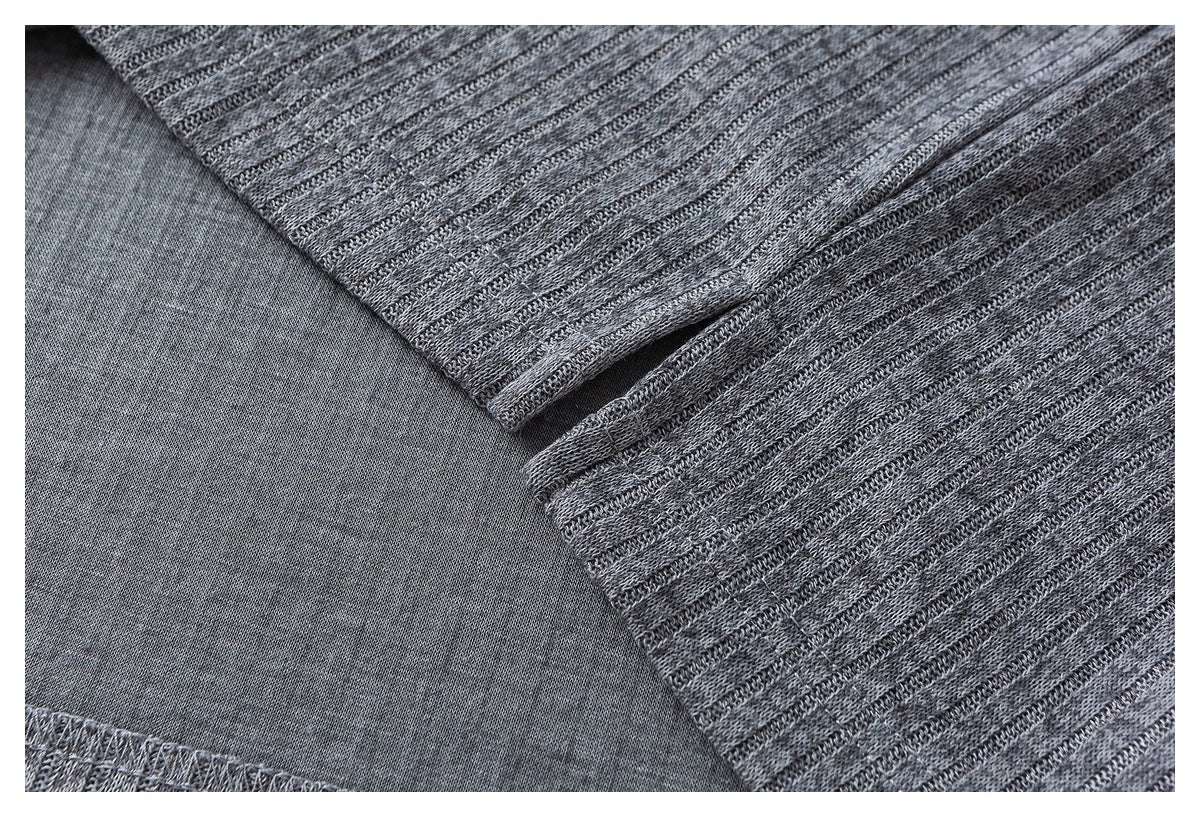 Close-up of a gray knit garment seam and folded edge, showing the reverse side of the fabric.