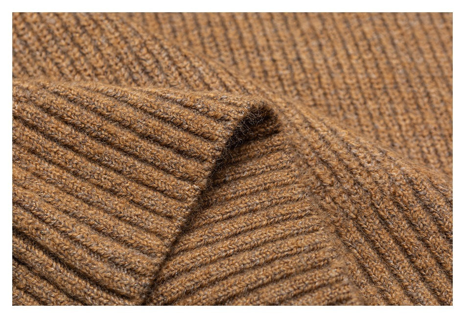 Close-up of camel-brown ribbed knit fabric with a folded edge and visible stitching.
