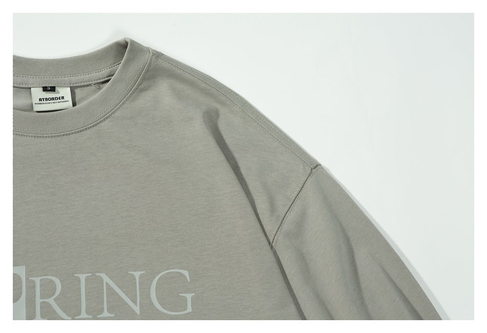 Close-up of the shirt's front neckline and shoulder seam, with part of the white chest graphic visible.