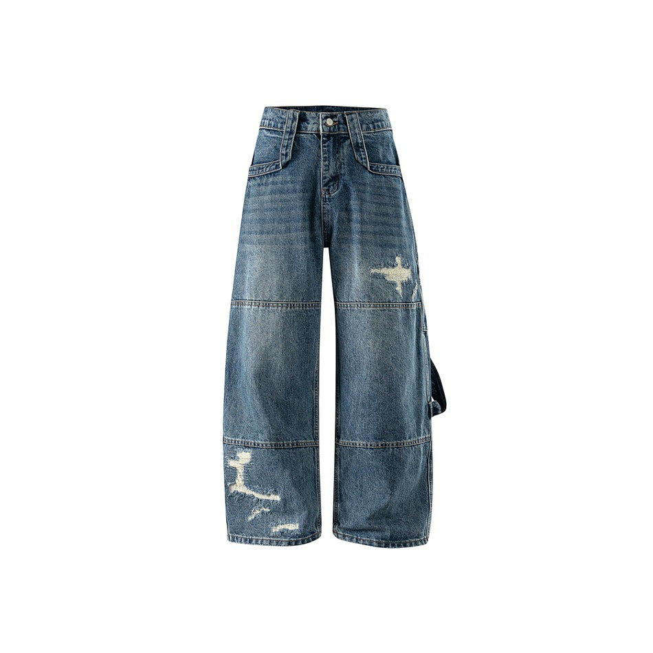 Front view of washed blue wide-leg distressed denim jeans with knee seams and ripped details on a white background