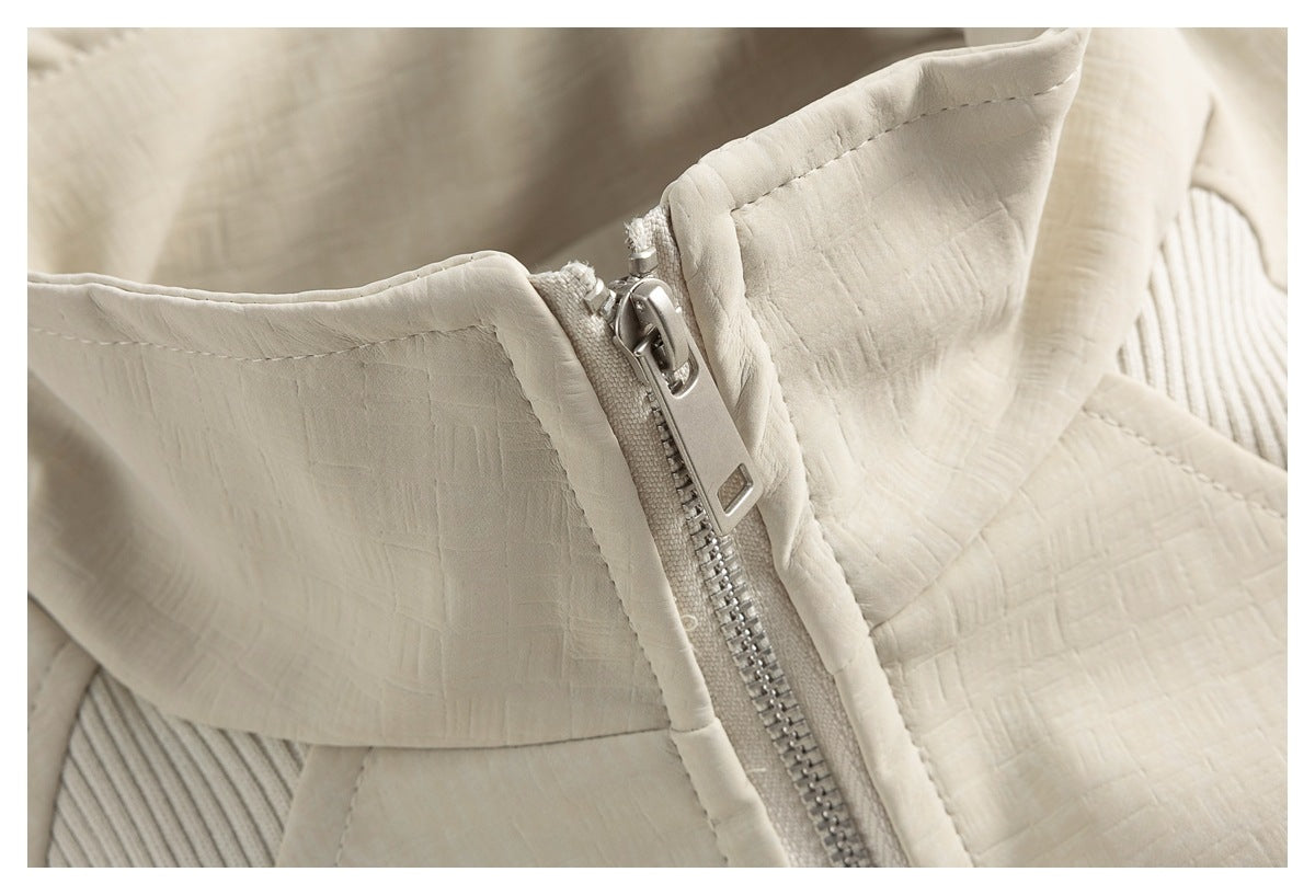 Close-up of the ivory jacket's silver zipper, padded collar, and textured fabric.