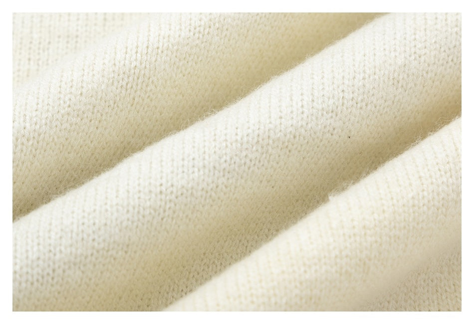 Macro view of cream knit fabric draped in soft folds.