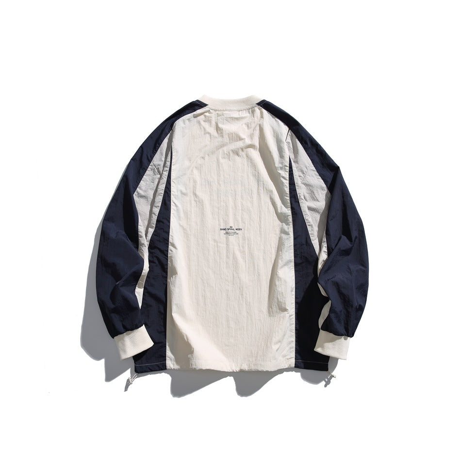 Back view of an ivory pullover with navy sleeves and side panels, ribbed cuffs, and a small center-back print.