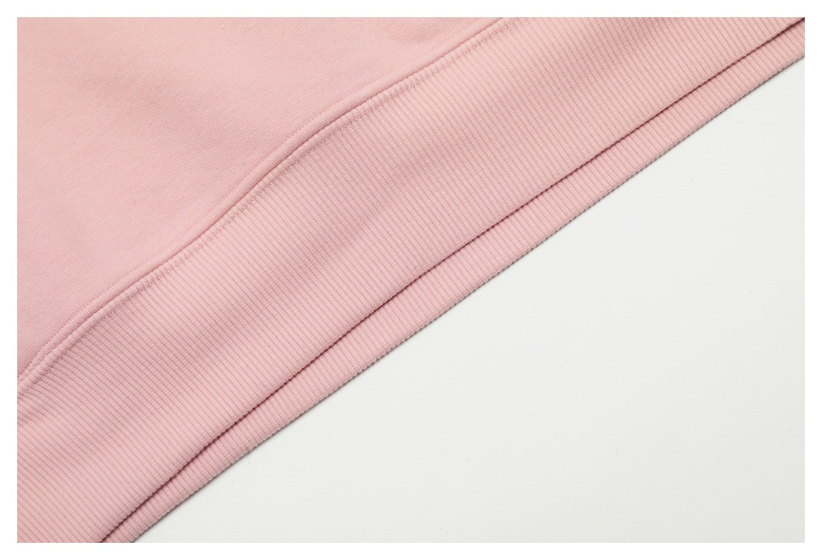 Close-up of the pale pink garment's rib-knit hem and stitched seam.