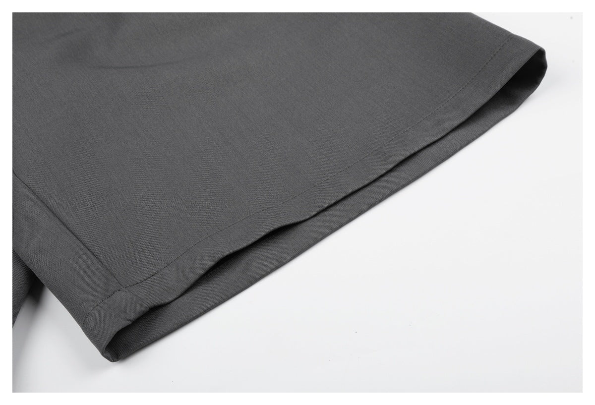 Close-up of the charcoal gray pants' stitched, folded hem against a white background.