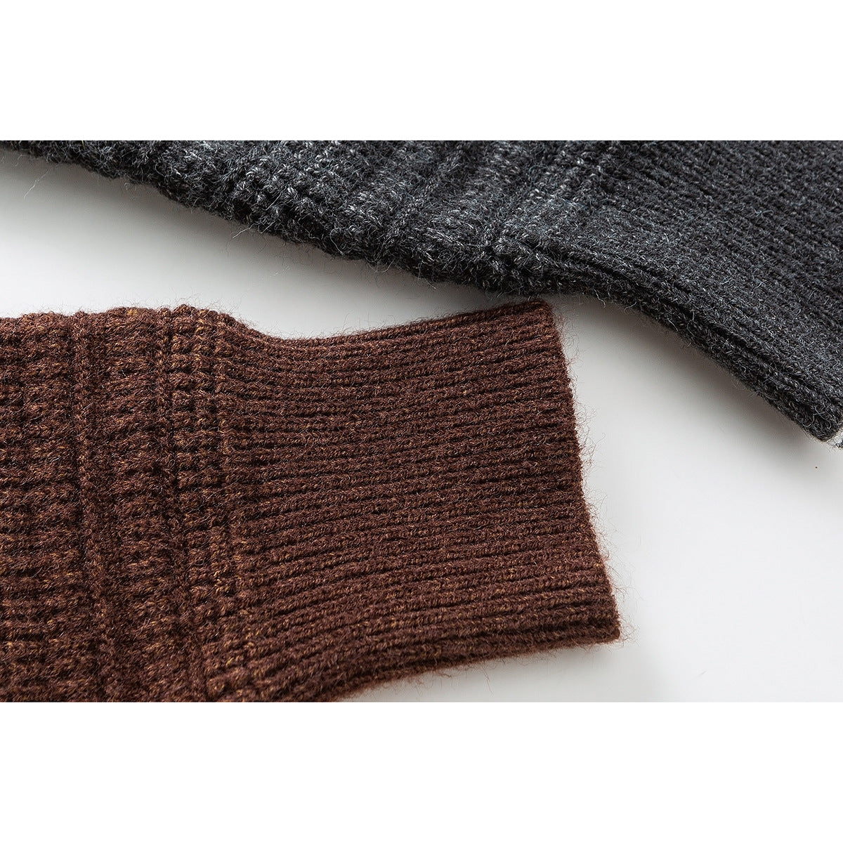 Close-up of brown ribbed cardigan cuff beside a charcoal gray knit sleeve.