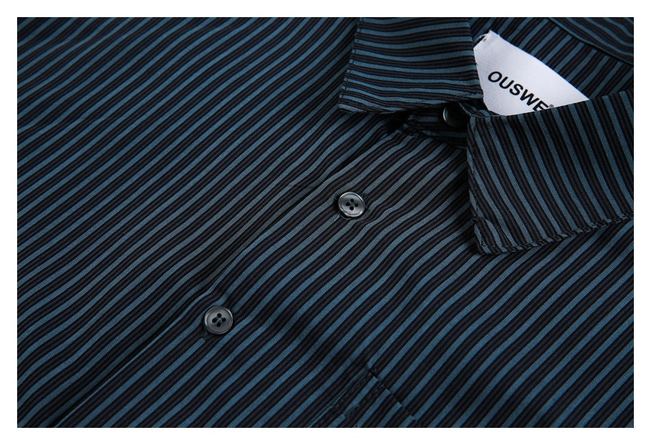 Close-up of black and blue-gray striped shirt fabric, front buttons, collar, and neck label.