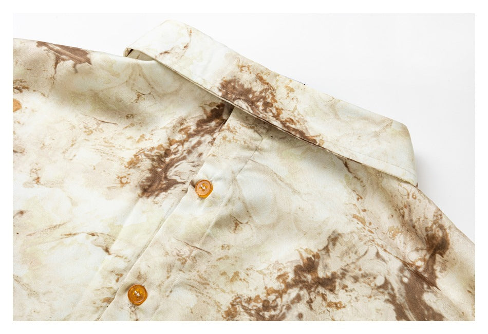 Close-up of the shirt collar and button placket in a cream and brown abstract print.