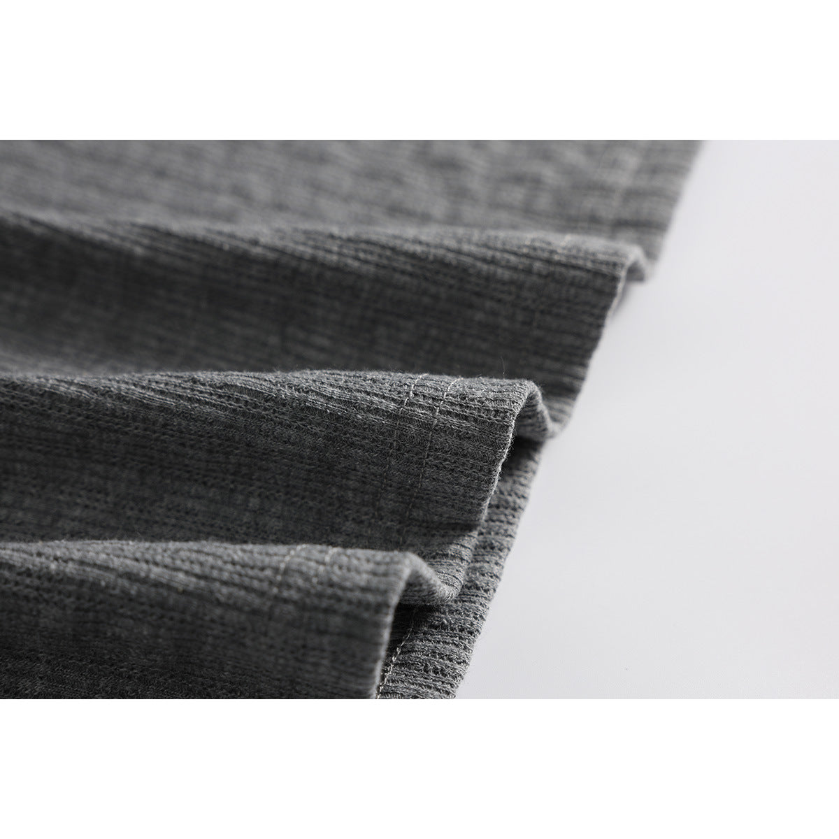 Close-up of layered gray ribbed fabric edges and stitching.
