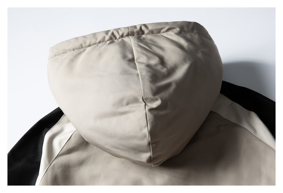 Close-up of a light beige hood with a center seam on a black-and-beige jacket.