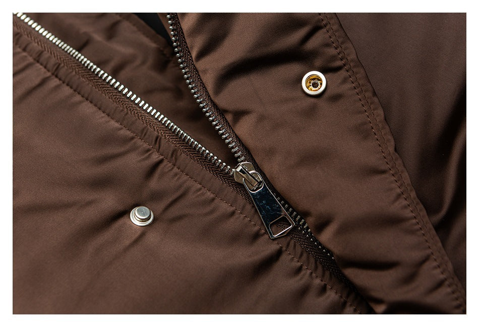 Close-up of a dark brown jacket's metal zipper and snap-front closure.