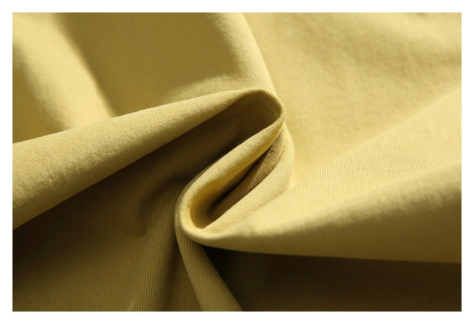 Close-up of mustard-yellow fabric folded to show its fine ribbed texture.