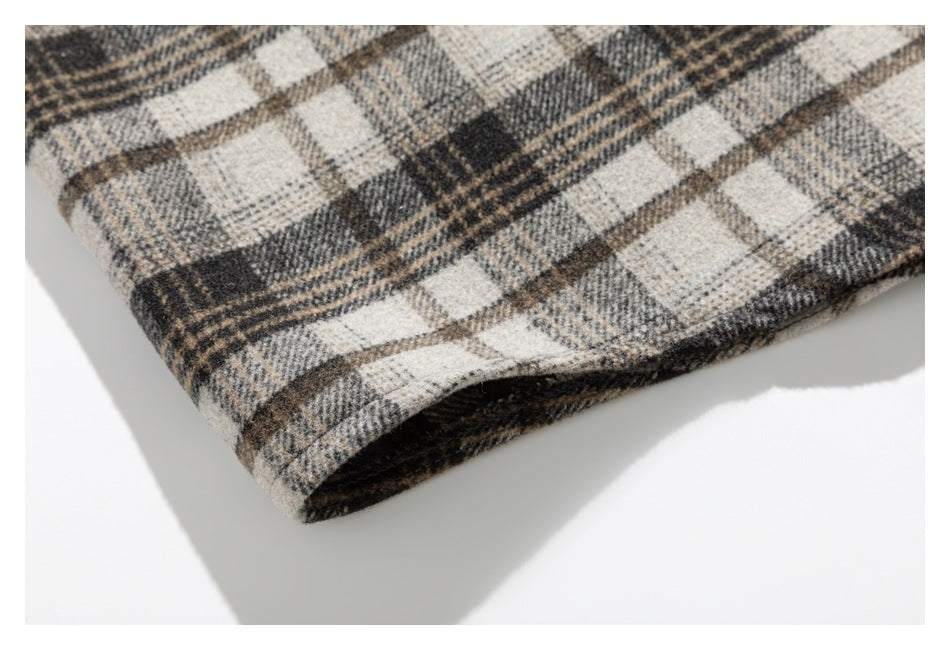 Close-up of a folded hem showing the beige, gray, and brown plaid pattern and dark inner edge.