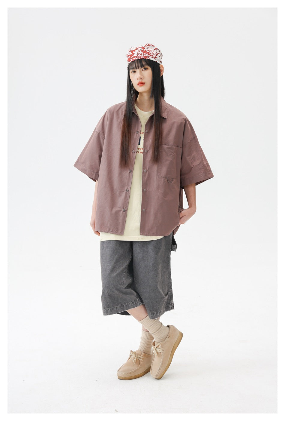 Front view of a model in a dusty rose oversized short-sleeve button-up shirt with a chest pocket.