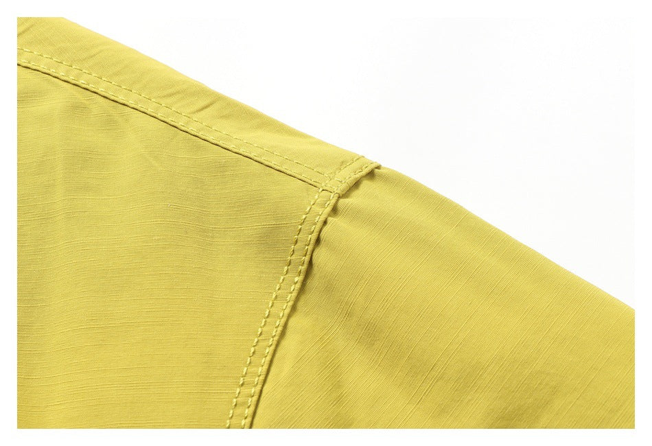 Close-up of the yellow jacket shoulder seam and topstitched panel.
