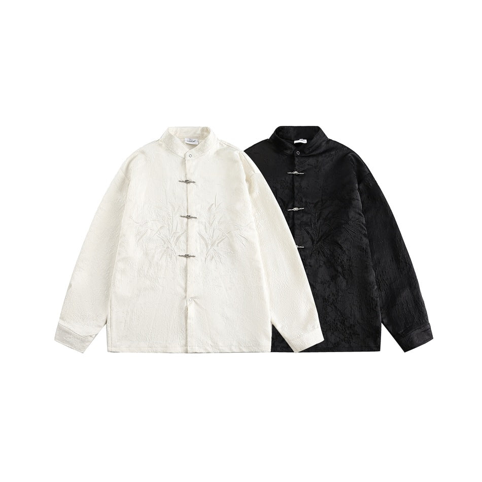 Ivory and black stand-collar jackets displayed together, both with bamboo embroidery and metal frog closures.