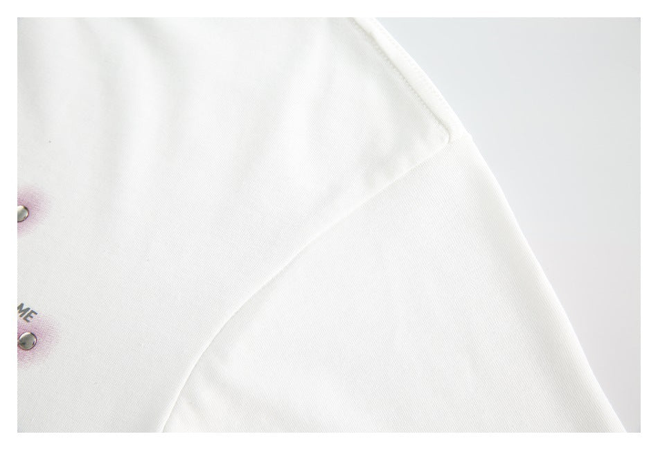 Close-up of the white top's shoulder seam and sleeve area.