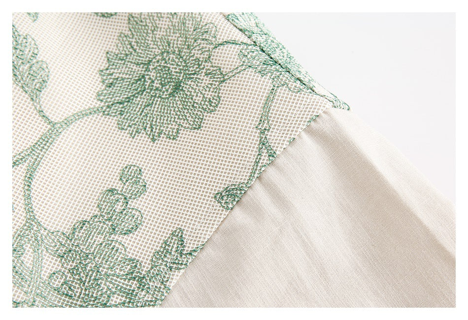 Close-up of the seam joining green floral-patterned cream fabric to a plain cream shirt section.