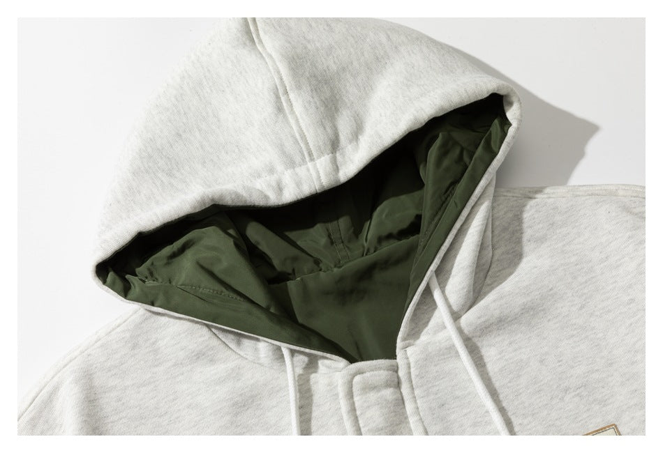 Close-up of a light gray hoodie hood with dark olive lining and matching drawstrings.