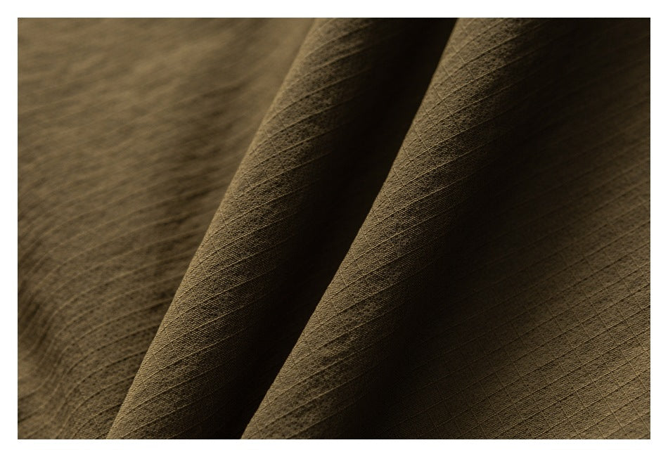 Macro view of the olive-brown trousers' subtly textured fabric and folds.