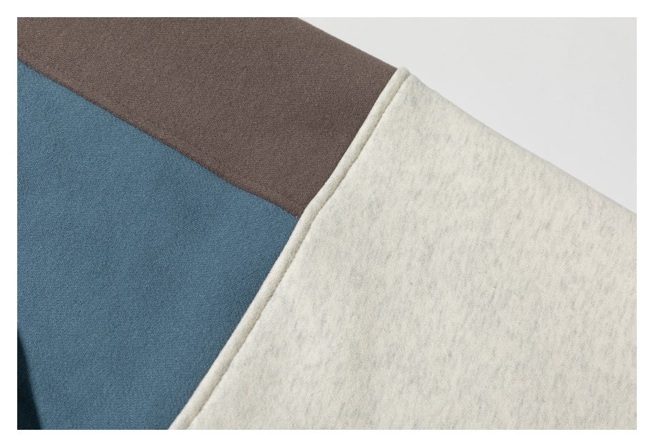 Close-up of cream, blue-gray, and brown fabric panels with a bound edge.