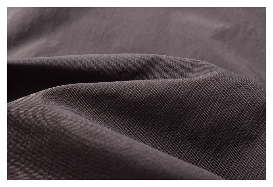 Close-up of dark charcoal-gray fabric folded into soft ridges.