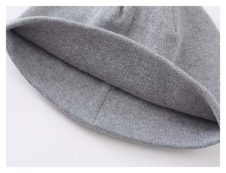 Close-up of the folded opening and inside edge of a light gray knit beanie.