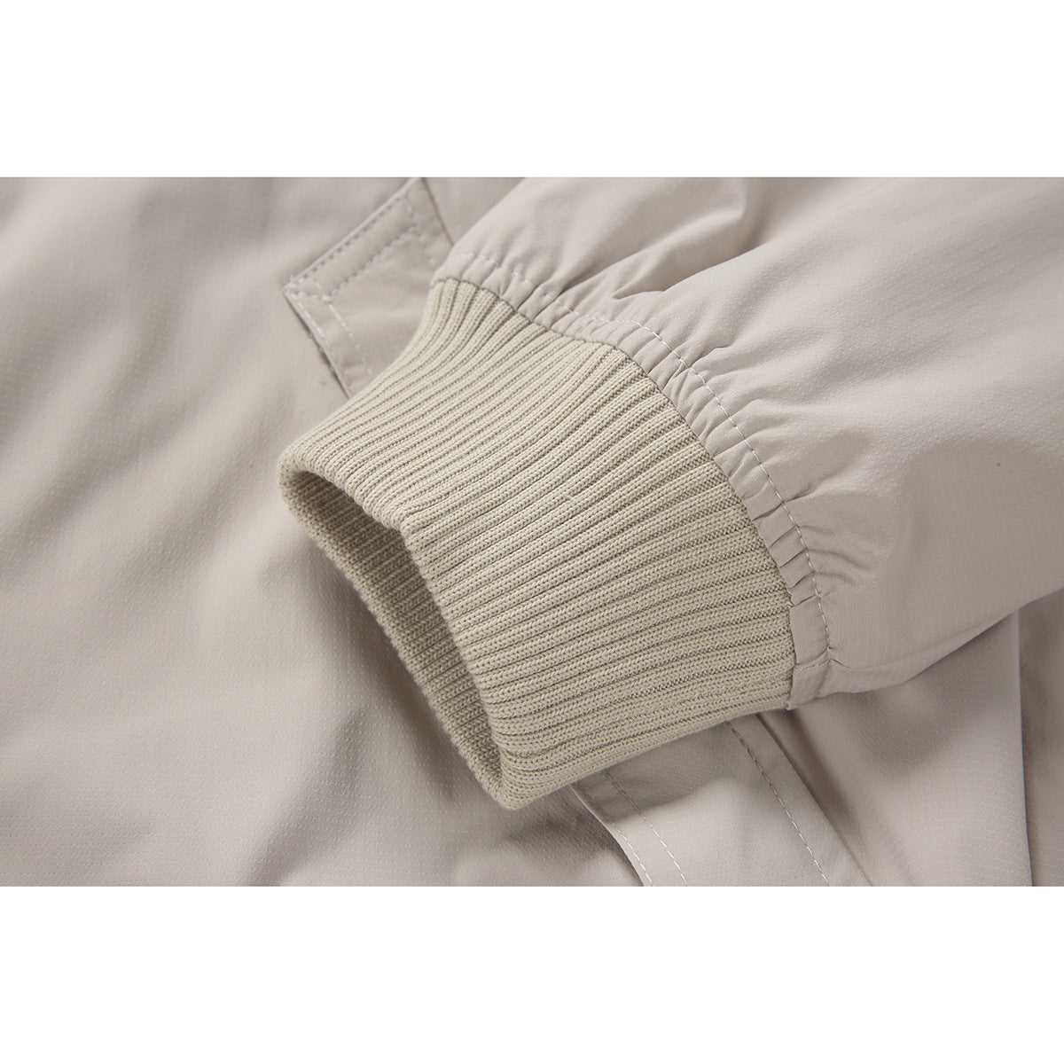 Close-up of the light beige jacket sleeve and ribbed knit cuff.
