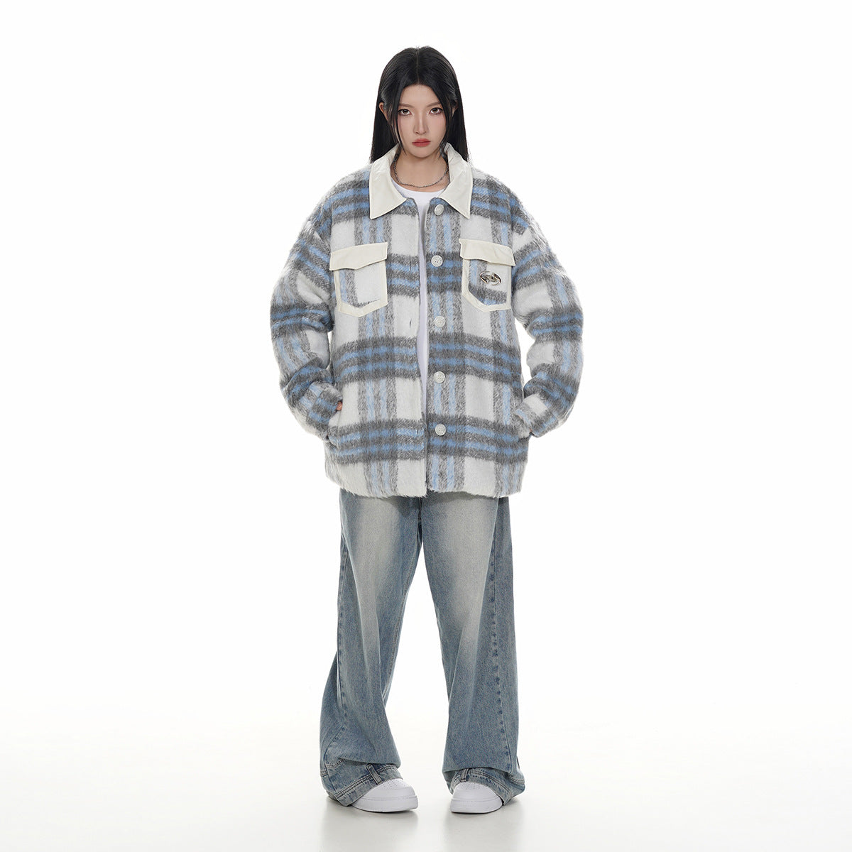 Full-length model wearing a gray, white and blue plaid button-up jacket with cream pockets, wide-leg jeans and white