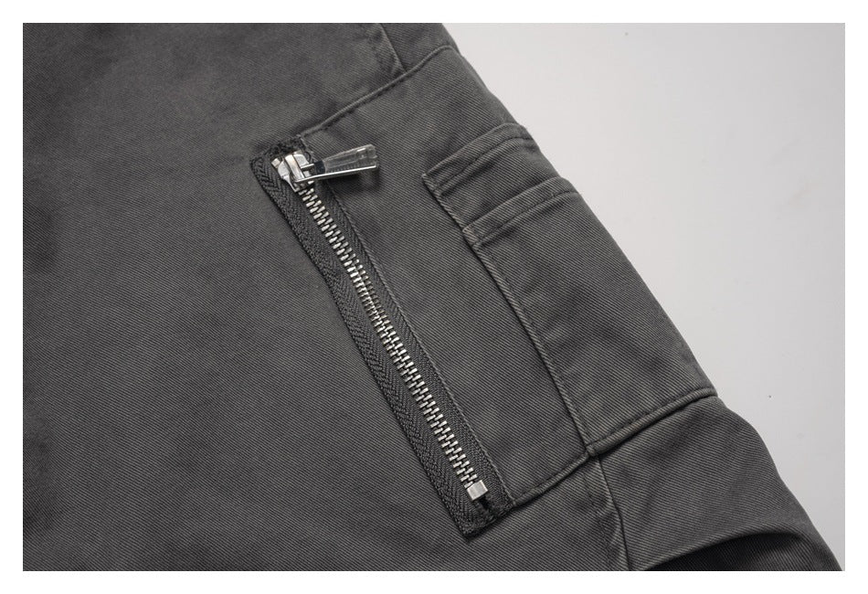 Close-up of a vertical silver zip pocket on a charcoal jacket.