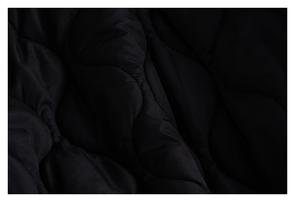 Close-up of black quilted garment lining with curved stitched sections.