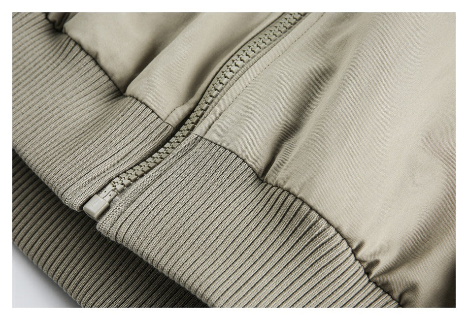 Close-up of the jacket's front zipper and wide ribbed beige hem.