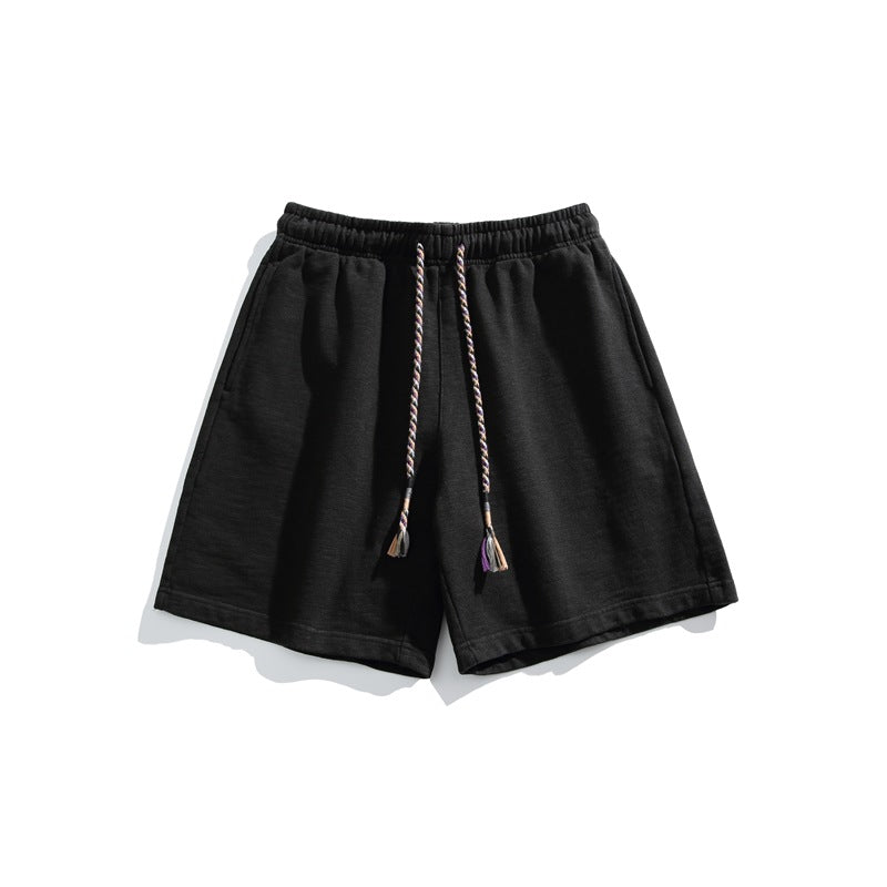 Black textured knit shorts flat lay with elastic waist and braided tassel drawstring