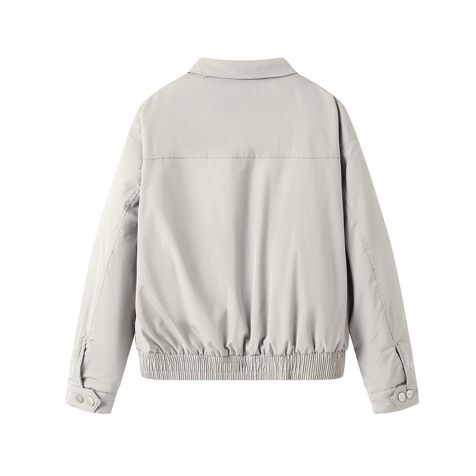Back view of a light gray jacket with long sleeves, a horizontal shoulder seam, and an elasticized hem.
