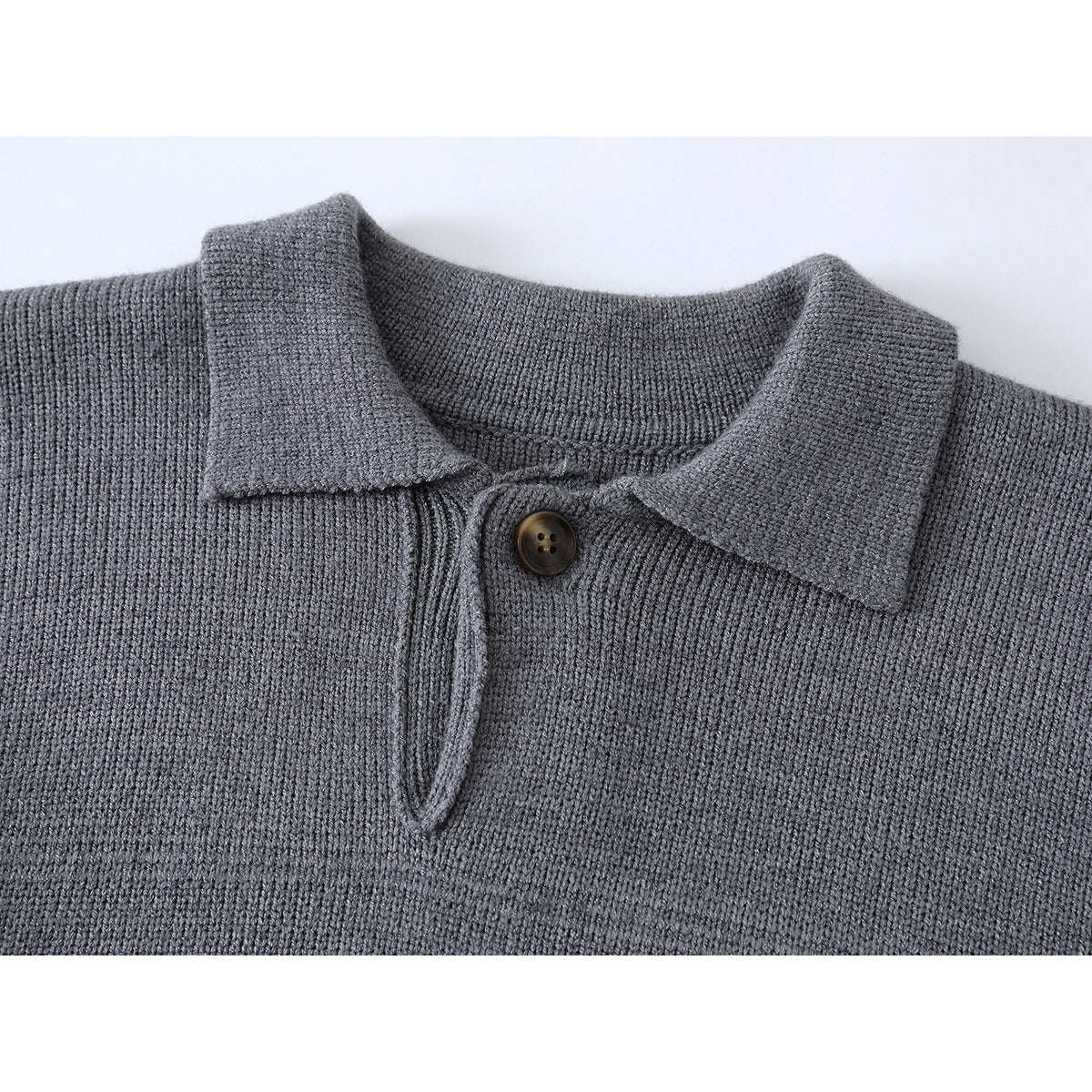 Close-up of a gray knit sweater's polo collar, button, and short placket.