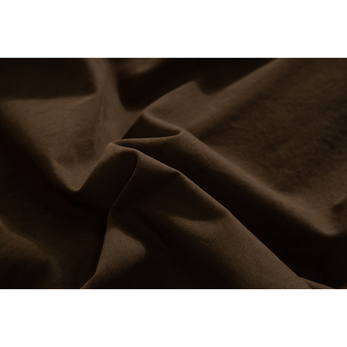 Close-up showing the brown skirt fabric gathered into soft folds.