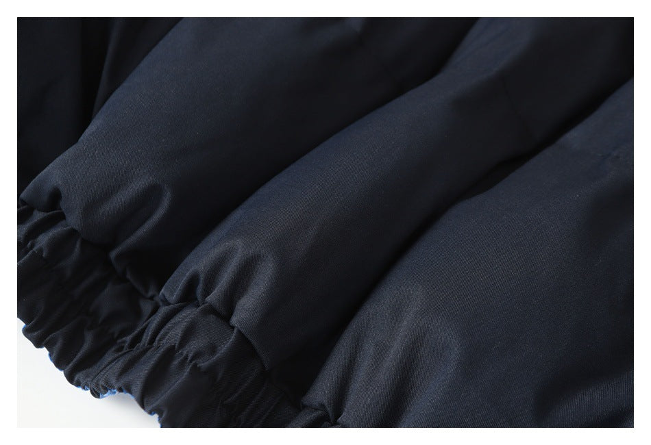 Close-up of dark navy jacket fabric gathered along an elastic edge with stitched sections.