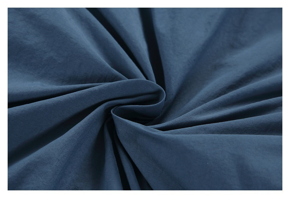 Close-up of dark blue fabric gathered into soft folds, showing its surface texture.