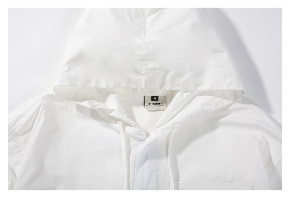 Close-up of the white jacket’s hood, neckline, drawstrings, and sewn-in size label.