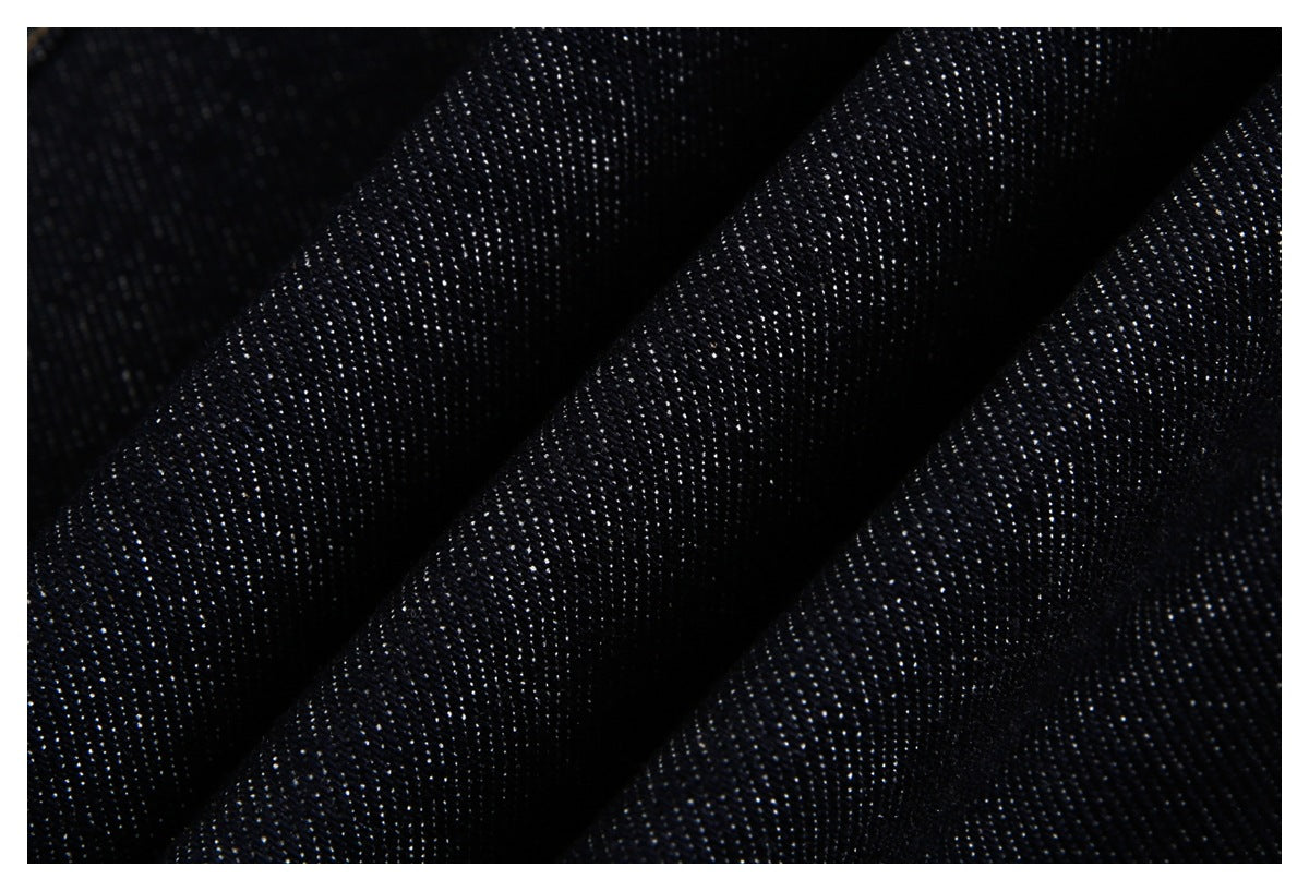 Macro view of the dark indigo denim weave, folded to show its textured surface.